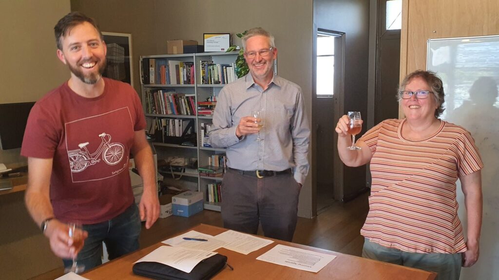 Three people smiling at the Co-operative Formation Meeting